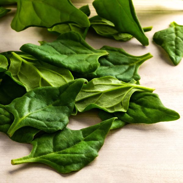 Fresh raw New Zealand spinach leaves on a cutting board close up